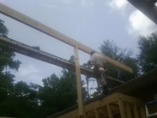 Carpenter setting a ridge beam over a new addition frame — Ice Dam Removal by Roofing Brothers in Staplehurst
