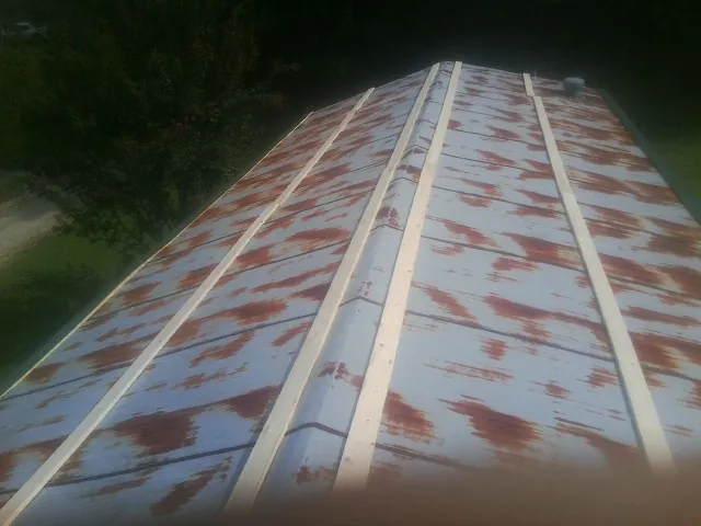 Rusted metal roof panels with new wood purlins before replacement — Storm Damage Roof Repair in Staplehurst by Roofing Brothers