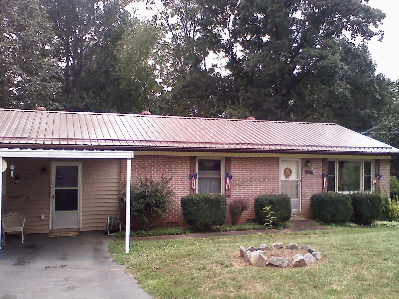 Bronze metal roof and carport on a brick ranch home — Roof Repair work by our crew in Staplehurst